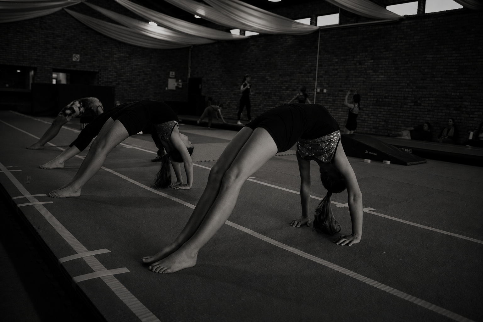 Coach spotting a gymnast during a tumbling skills clinic