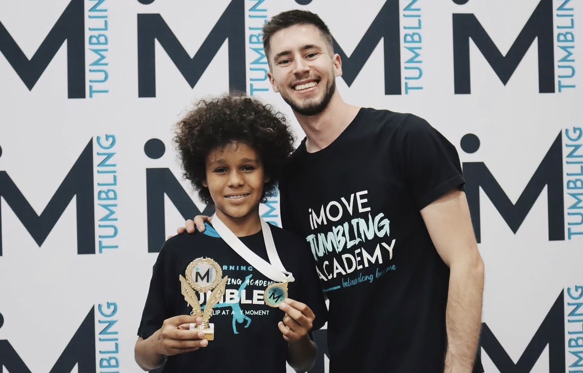 Coach and young athlete celebrating with a medal
