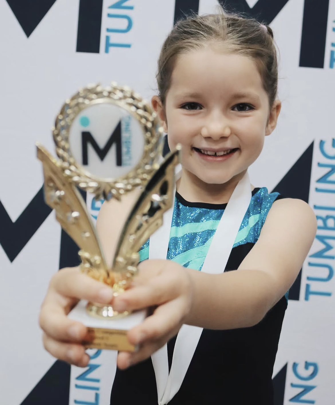 Young iMove gymnast holding her trophy