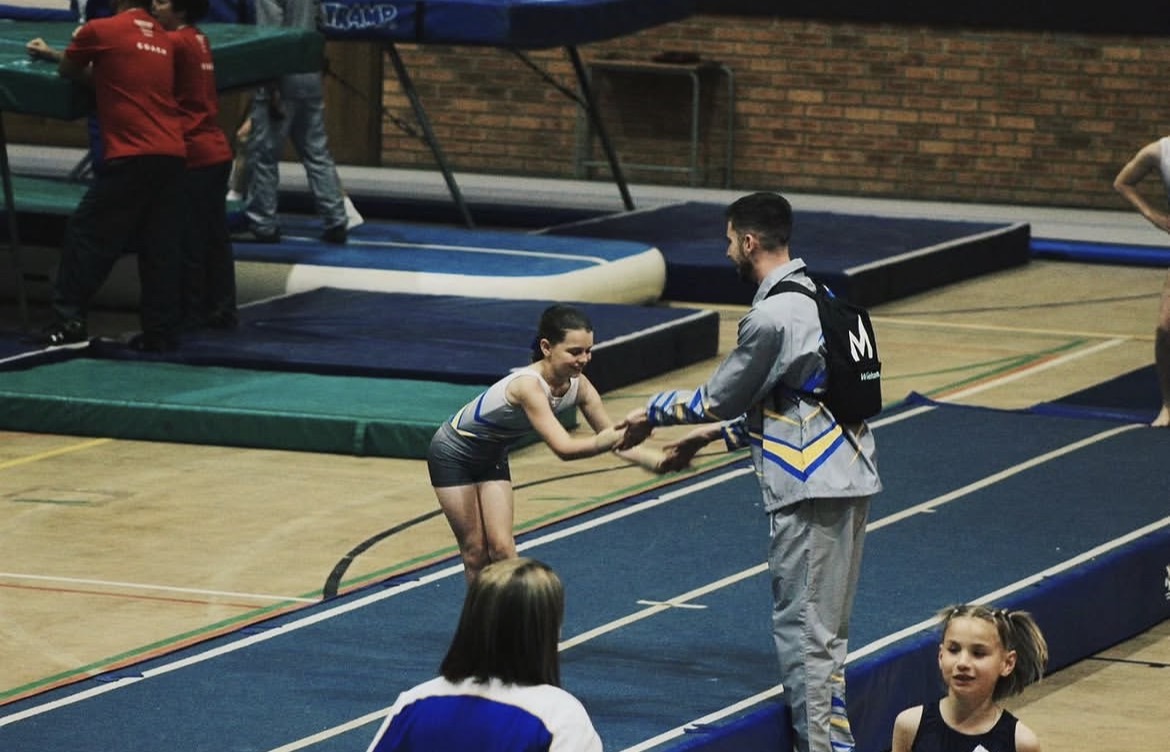 Coach greeting an athlete after a tumbling pass